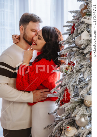 lovely couple dancing in front of christmas tree 117574711