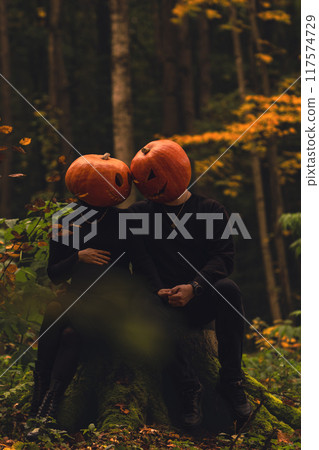 couple with pumpkin head in fall forest couple with pumpkin head in fall forest 117574729