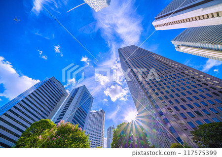 Tokyo cityscape in Japan: An airplane passes over Shinjuku...Tokyo Metropolitan Government Building in the background. Inbound tourism revives, a ray of hope for a new era = August 20th Tokyo cityscape in Japan: An airplane passes over Shinjuku...Tokyo Metropolitan Government Building in the background. Inbound tourism revives, a ray of hope for a new era = August 20th 117575399