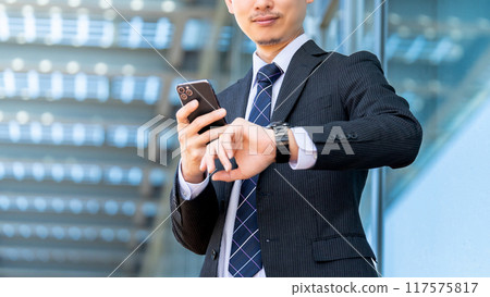 Japanese male businessman looking at his watch 117575817