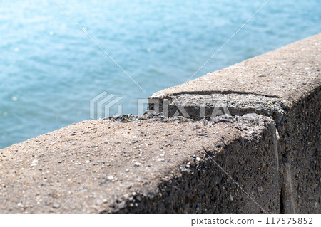 Cracked concrete wall on the beach Cracked concrete wall on the beach 117575852