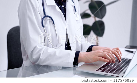 Doctor woman is using laptop computer at glass table in clinic. Medicine and pharmacy concept Doctor woman is using laptop computer at glass table in clinic. Medicine and pharmacy concept 117576059