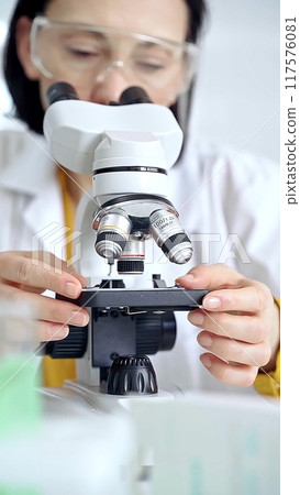 Woman scientist using microscope in laboratory. Microbiology science concept 117576081
