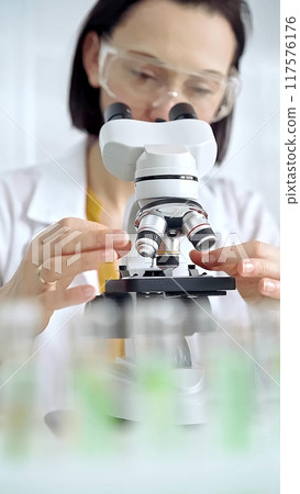 Woman scientist using microscope in laboratory. Microbiology science concept 117576176