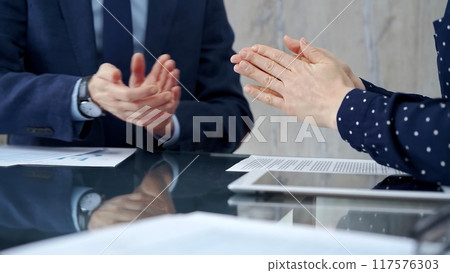 Unrecognizable business people shaking hands and clapping over g Unrecognizable business people shaking hands and clapping over g 117576303