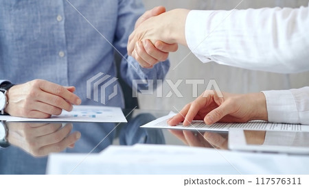 Business people shaking hands over contract agreement and financ Business people shaking hands over contract agreement and financ 117576311