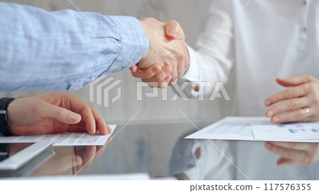 Business people shaking hands over contract agreement and financ Business people shaking hands over contract agreement and financ 117576355