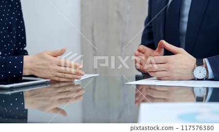 Unrecognizable business people shaking hands and clapping over glass table after contract signing in office. Agreement and handshake themes Unrecognizable business people shaking hands and clapping over glass table after contract signing in office. Agreement and handshake themes 117576380