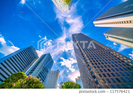 Tokyo cityscape in Japan: An airplane passes over Shinjuku...Tokyo Metropolitan Government Building in the background. Inbound tourism revives, a ray of hope for a new era = August 20th Tokyo cityscape in Japan: An airplane passes over Shinjuku...Tokyo Metropolitan Government Building in the background. Inbound tourism revives, a ray of hope for a new era = August 20th 117576421
