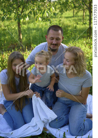 a family of four on a picnic in the park a family of four on a picnic in the park 117577033