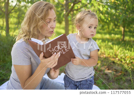 family reading the holy bible on a picnic in the garden 117577055