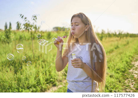 teen sister blowing soap bubbles for toddler teen sister blowing soap bubbles for toddler 117577426