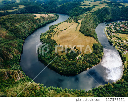 Aerial view of a river winding through lush green hills and forests Aerial view of a river winding through lush green hills and forests 117577551