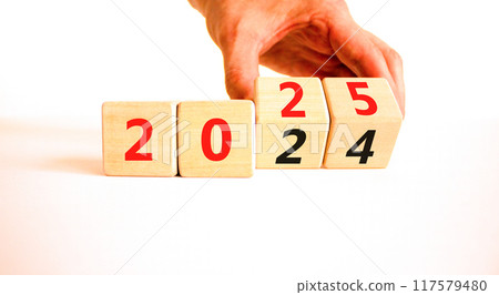 Business concept of 2025 new year symbol. Businessman turns wooden cube and changes number 2024 to 2025. Beautiful white table white background, copy space. Business 2025 happy new year concept. 117579480