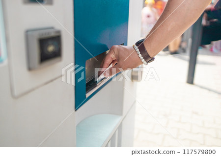 Caucasian tourist guy buys a bus ticket for the first time using an electronic ticket machine at Krakow, Poland  117579800