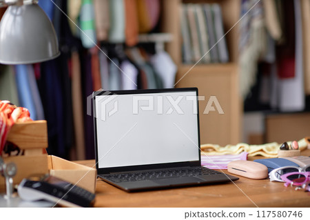 Close up on laptop with blank white screen on wooden table at thrift store, copy space 117580746