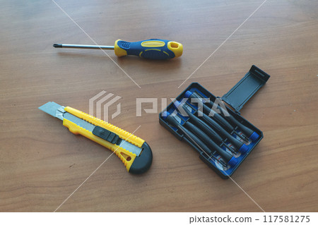 screwdrivers and a stationery knife on the table screwdrivers and a stationery knife on the table 117581275