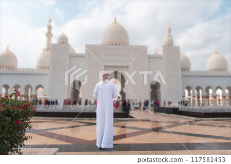 Visitor admiring Sheikh Zayed Grand mosque architecture in Abu Dhabi with prominent domes wearing kandora Visitor admiring Sheikh Zayed Grand mosque architecture in Abu Dhabi with prominent domes wearing kandora 117581453