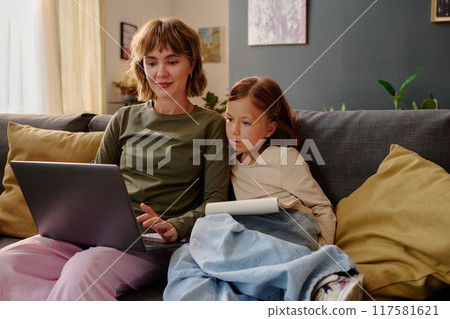 Caucasian mom showing new video game to her little girl Caucasian mom showing new video game to her little girl 117581621