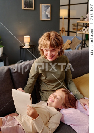 Caucasian mom and daughter fooling around with pen and sketchbook while spending time together Caucasian mom and daughter fooling around with pen and sketchbook while spending time together 117581627