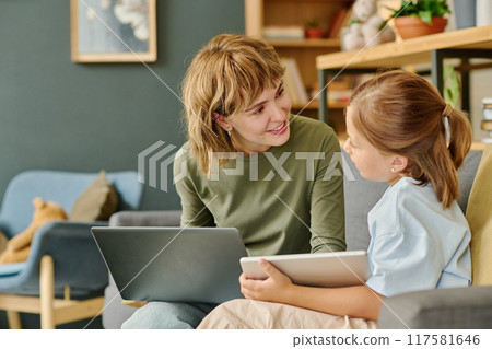 Blogger mom holding silver laptop and praising her child for her success 117581646