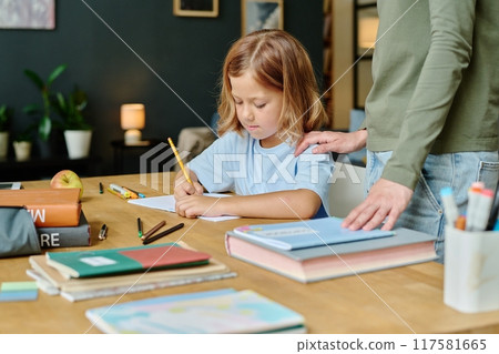 Little girl doing sums while her mother supporting her Little girl doing sums while her mother supporting her 117581665