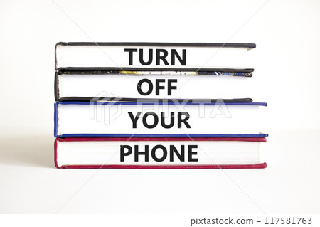 Turn off your phone symbol. Concept words Turn off your phone on books. Beautiful white table white background. Business psychological turn off your phone concept. Copy space 117581763