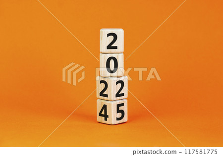 Business concept of 2025 new year symbol. Beautiful turned wooden cube and changed number 2024 to 2025. Beautiful orange table orange background, copy space. Business 2025 happy new year concept. 117581775