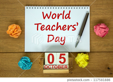 White note with inscription 'World Teachers' Day' on beautiful wooden table, colored paper, metalic pen and wooden calender with date october 05. Concept. White note with inscription 'World Teachers' Day' on beautiful wooden table, colored paper, metalic pen and wooden calender with date october 05. Concept. 117581886