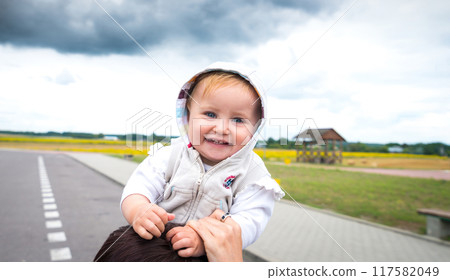 Adorable Baby Smiling On Mom'S Shoulders Near The Road 117582049