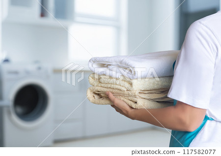 Cleaning lady aprons holding a pack of clean towels. 117582077