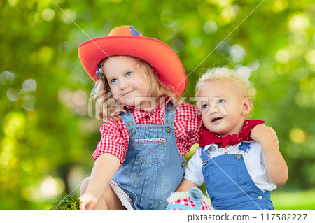 Cowboy kids playing with toy horse Cowboy kids playing with toy horse 117582227