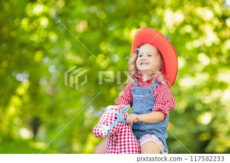 Cowboy kids playing with toy horse Cowboy kids playing with toy horse 117582233