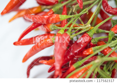 Image of dried red chili peppers on a table 117582317
