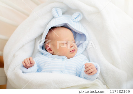 Newborn baby boy in hospital cot 117582369