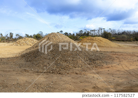 Crushed rock in readiness for construction of a new dirt road 117582527