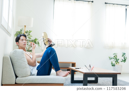 Young man putting on make-up in the living room Young man putting on make-up in the living room 117583206