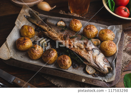 Sea Bass Stuffed with Sorrel and Baked with New Potatoes 117583298