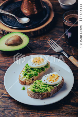 Toasts with mashed avocado, cream cheese and boiled egg Toasts with mashed avocado, cream cheese and boiled egg 117583343