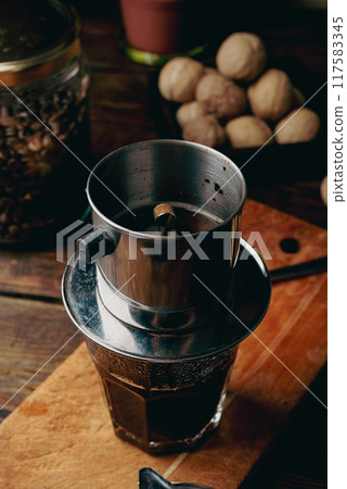 Coffee brewing in traditional Vietnamese drip filter 117583345