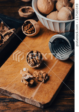 Cracked walnuts and nutcracker Cracked walnuts and nutcracker 117583349