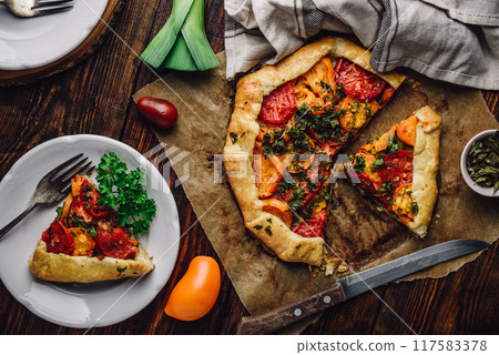 Sliced tomato galette on baking paper Sliced tomato galette on baking paper 117583378