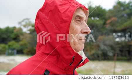 Man Taking Off The Raincoat Hood  117583613