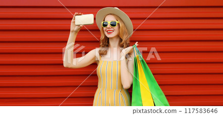 Beautiful happy woman taking selfie with phone, stylish smiling girl holding colorful shopping bags Beautiful happy woman taking selfie with phone, stylish smiling girl holding colorful shopping bags 117583646
