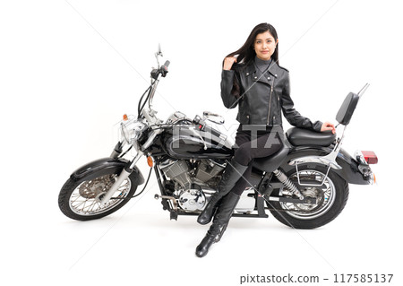 A biker girl sitting on a bike and brushing her hair back 117585137
