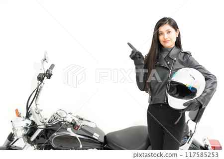 騎自行車的女孩站在自行車旁邊，拿著頭盔指著 117585253