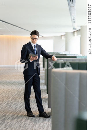 A businessman looking at a tablet A businessman looking at a tablet 117585957