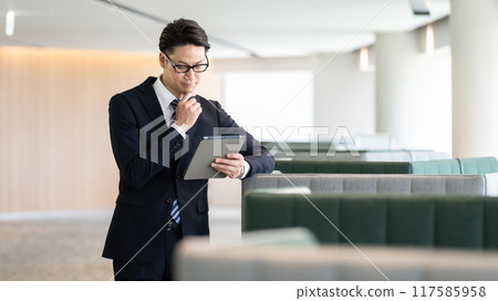 A businessman looking at a tablet 117585958