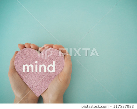 Hearts held in both hands with the word "mind" written on them, copy space 117587088