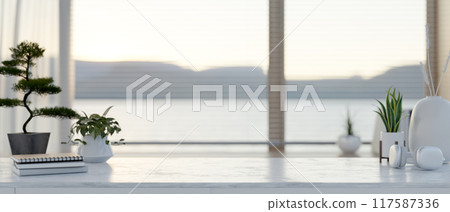 A modern white marble table in a contemporary room with a large window. 117587336